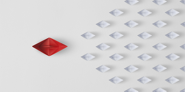 Red paper boat being followed by a flotilla of smaller white paper boats