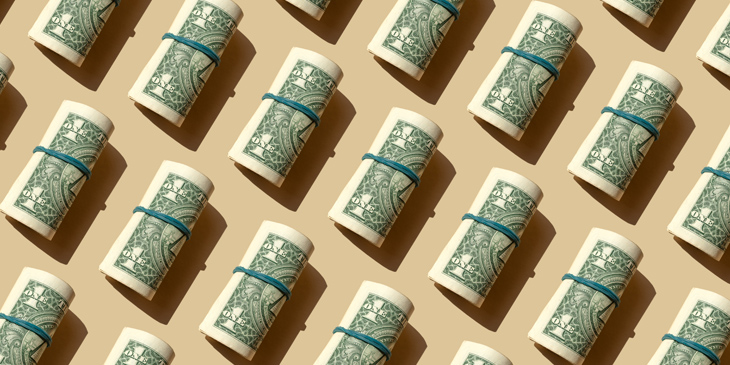 Roll of American dollars banknotes on the beige background