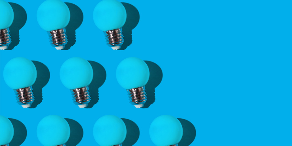 Blue turquoise glass bulbs pattern with hard shadow, on the left side, on blue background