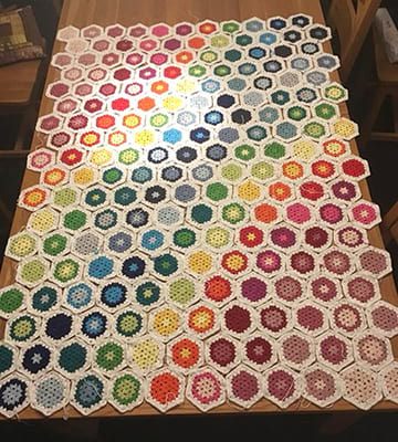 Crochet bedspread arranged before being stitched together