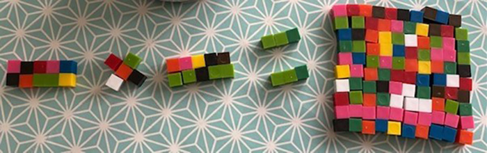 Cube blocks being used numerically to display 10 times 10 equals 100