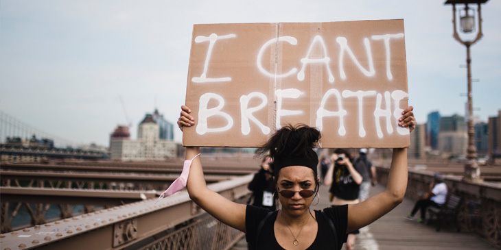 Person holding sign 'I can't breathe'