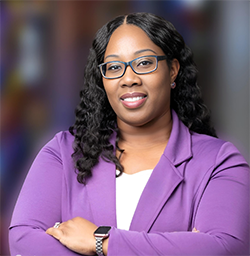 A profile photo of Dr JoAnn Scales, wearing a purple suit jacket with a white top underneath