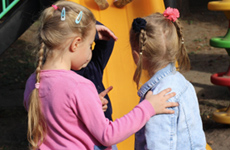 Three young children talking with each other