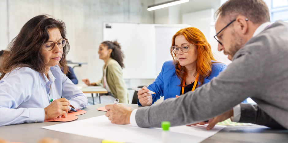 A group of teachers seated together at a table, participating in an activity 