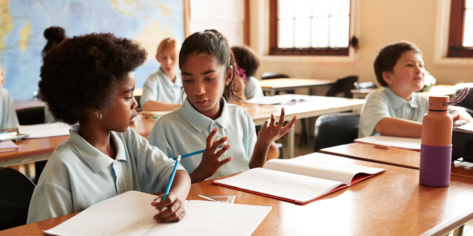 Students in a classroom helping each other while doing mathematics