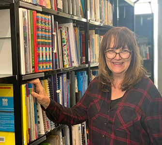 Fiona librarian next to bookcase