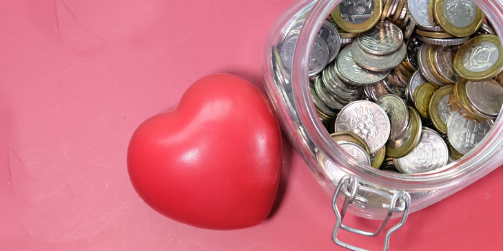 A love heart next to a jar filled with coins