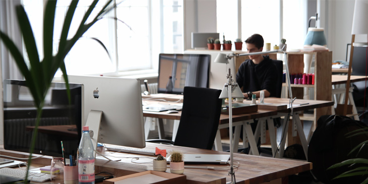 A modern office setting with iMacs on every desk