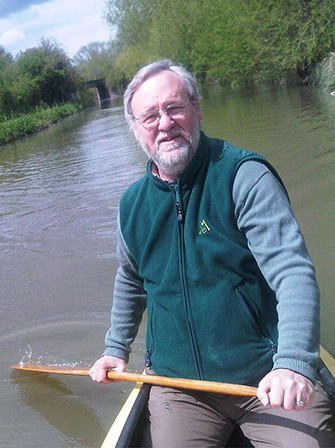 John Mason paddling a boat down river