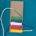 Some yarn being weaved on a board