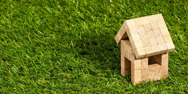 A small wooden house in a field of grass