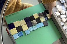 A green board, with different coloured pieces of square tiles placed on top