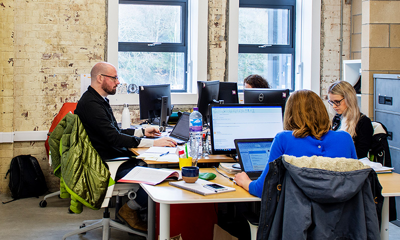 A photo of the Radix office with workers around a desk