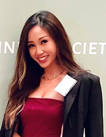 Rina Lai in a red dress with a suit jacket over the top