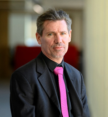 Steven Walker in a black suit and pink tie