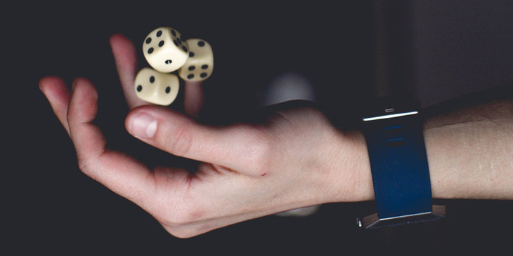 A hand juggling three dice