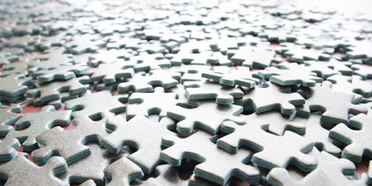 Blank jigsaw pieces spread out across a surface