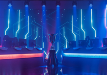 An eSports arena with a winner trophy in the middle, either side there is 5 seats with a monitor each