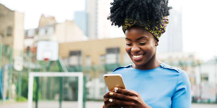 Woman using smart phone in city